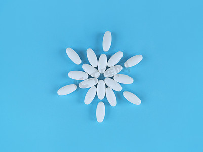由蓝色背景上的白色药片制成的花形。