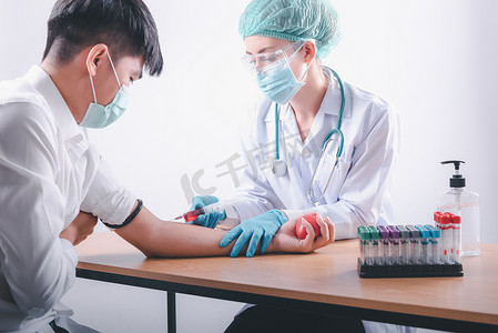 医生正在实验室测试中从男性患者身上收集血液样本测试注射器注射液。