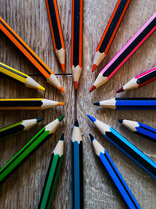 五颜六色的铅笔蜡笔在木地板上围成一圈