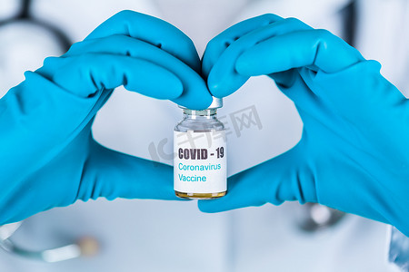 身穿制服和戴面罩的女医生或护士在实验室中以一种带有 COVID-19 冠状病毒疫苗标签的心脏药瓶疫苗瓶形式进行保护