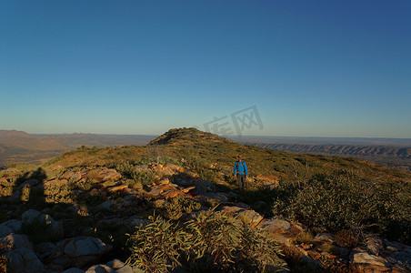 男子在澳大利亚西麦克唐纳国家公园爱丽丝泉外的桑德尔山顶徒步旅行