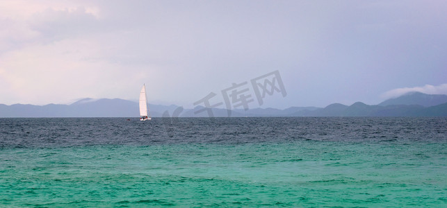 在泰国普吉岛附近的安达曼海碧绿的海水中航行的帆船。