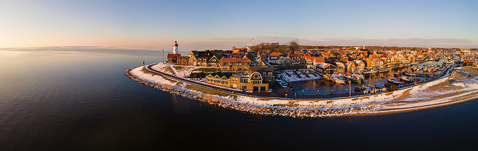 荷兰 Urk Flevoland 灯塔的全景，冬季 Urk 海滩上覆盖着白雪