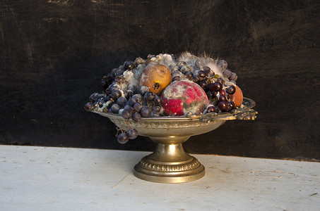 花瓶古董摄影照片_装有各种腐烂水果的古董底座盘花瓶