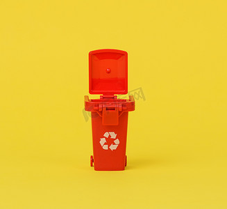 黄色背景中红色塑料垃圾分类箱的缩影