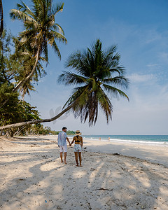 热带春摄影照片_夫妇在泰国度假，春蓬省，白色热带棕榈树海滩，Wua Laen 海滩春蓬地区泰国，棕榈树挂在海滩上，夫妇在泰国度假