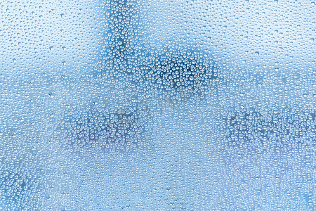 带有大滴水或蓝色雨的湿玻璃。