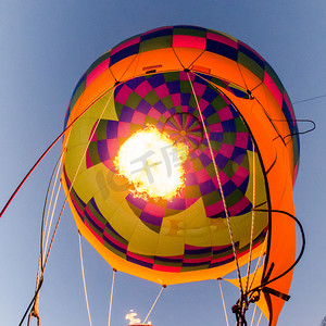 加热空气摄影照片_在热气球节上，火加热了热气球内的空气