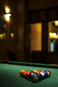 台球摄影照片_在舒适的黑暗酒吧内部台球桌上的台球