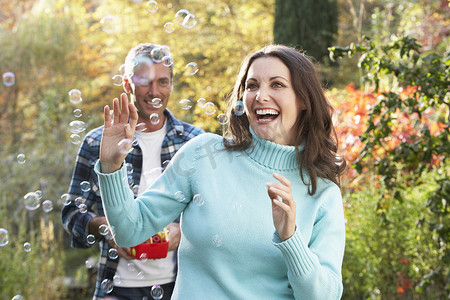夫妇在户外秋天风景与泡泡机