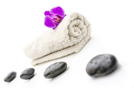 保健石摄影照片_毛巾上的按摩石和紫兰花