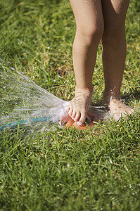 南非开普敦女孩玩草坪洒水器