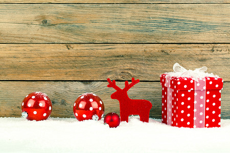 圣诞节的红色礼物在有雪的木背景