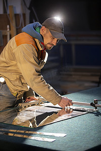 人工生产摄影照片_一个工人用玻璃刀切割镜子。