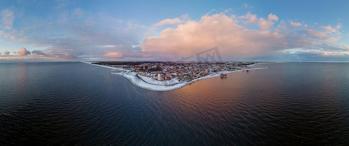 urk摄影照片_荷兰 Urk Flevoland 灯塔的全景，冬季 Urk 海滩上覆盖着白雪