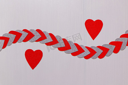 纹理情人节活动摄影照片_两颗红心分开，带纹理的白色心串