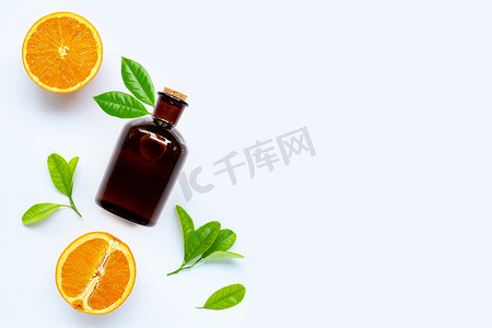 高维生素 C，新鲜橙色水果与白色背景上的精油瓶。