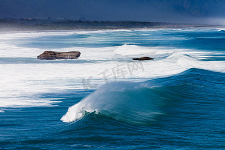 海浪汹涌摄影照片_汹涌的海水冲破新西兰海岸的海浪