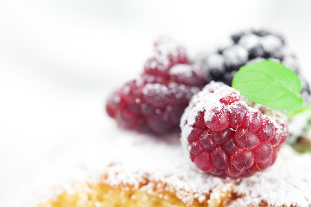 糖霜摄影照片_“白背上有糖霜、覆盆子、黑莓和薄荷的蛋糕”