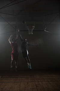 两个篮球运动员：一个投篮，一个跳跃