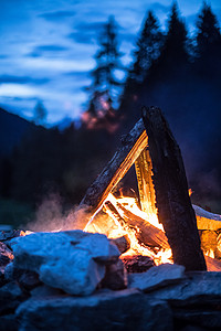 在夏天，森林里用黄色和红色的火焰露营篝火。