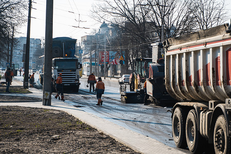 KYIV, UKRAINE - September 10, 2020：工业沥青摊铺机在街上的道路施工现场铺设新鲜沥青。