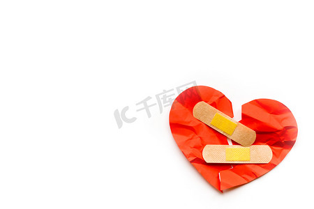 破碎的红心符号与白色背景上的医疗补丁，爱情概念。