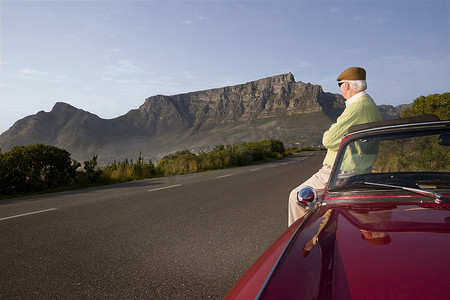 南非开普敦信号山靠老式赛车的老人欣赏美景
