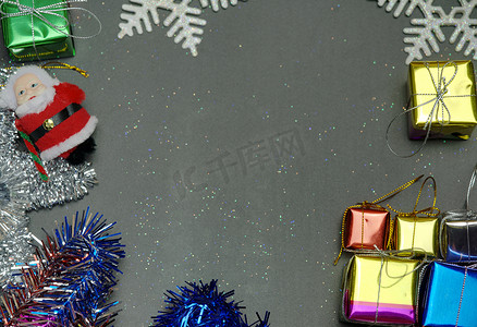 书籍封面装饰摄影照片_优雅的圣诞背景复制空间，金色雪花和铃铛，闪亮的礼盒，黑色木质背景。