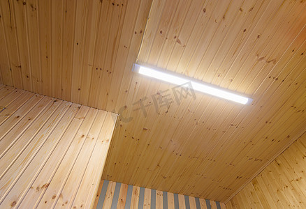 从带有 LED 日光灯的木质衬里看天花板