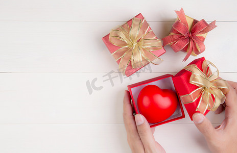 情人节，手开红色礼盒，心形木制白色背景，庆祝和周年纪​​念，给予爱，呈现浪漫和惊喜，节日和节日概念。