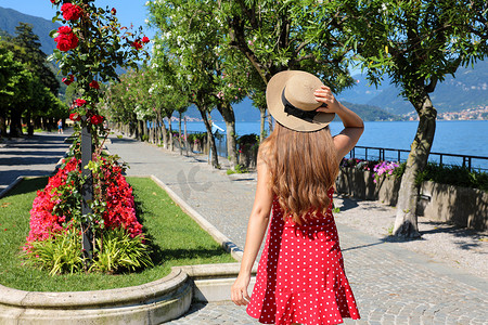 迷人的年轻女子沿着意大利科莫湖 Bellagio 鲜花长廊散步