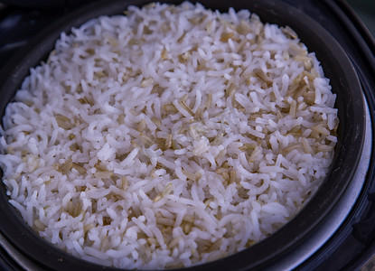 电饭锅海报摄影照片_茉莉香米与粗糙米混合在电饭锅中蒸煮。