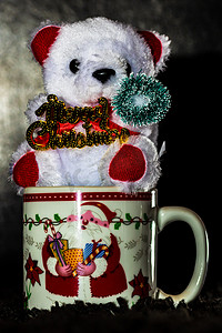 在黑色隔离的圣诞杯中装饰的泰迪熊。