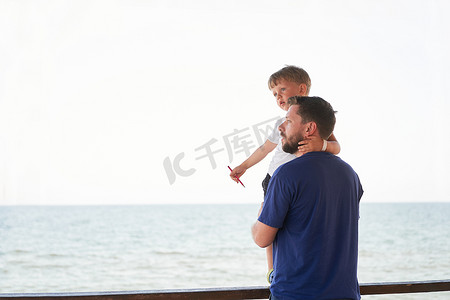 海平线摄影照片_父子一起在外面展示手指海平线背 男人孩子度过假期享受夏天