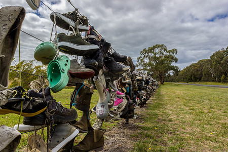 澳大利亚公路旁栅栏上的旧鞋。