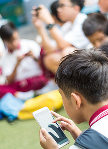 泰国曼谷-2018 年 4 月 19 日，许多学生在学校刹车期间玩智能手机