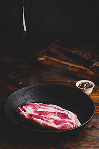 牛排煎锅摄影照片_在煎锅的未加工的猪颈肉牛排