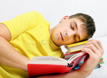 疲倦的少年睡在书上