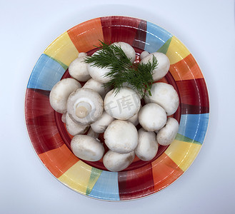 盘子里放着一小撮莳萝的香菇