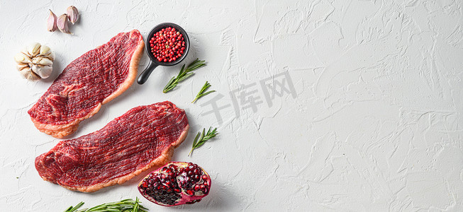 夫妇 picanha 牛排与迷迭香和石榴顶视图在白色带纹理的背景。