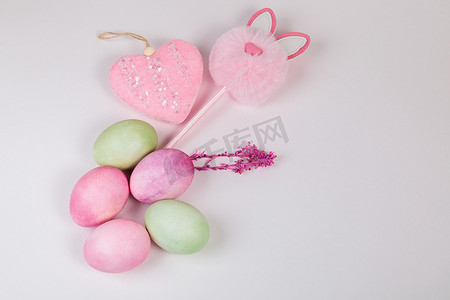 粉色彩蛋摄影照片_带有树枝的多色鸡蛋，在白色背景上有一个文本位置。