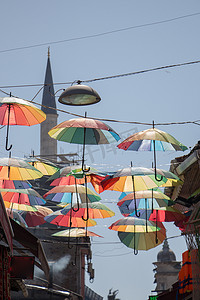悬挂图案摄影照片_悬挂在街道上方的彩色雨伞