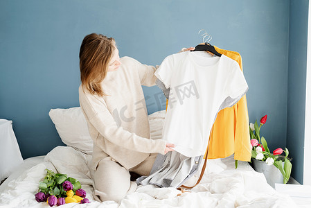 坐在家里床上整理衣服的年轻女人