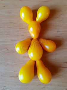 滑稽兔子摄影照片_用黄色西红柿制成的野兔的滑稽雕像