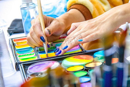 艺术家将画笔浸入颜料中。