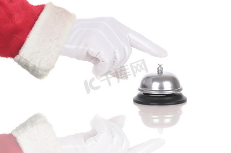 呼叫铃摄影照片_圣诞老人戴着手套的手伸过白色隔离的服务铃。