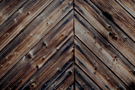 复古表面摄影照片_乡村风格的深色古色古香木墙，上面有陈旧、开裂的木板和钉子 — 粗糙的复古表面背景，带有复制空间