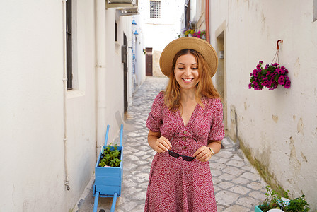 迷人的时尚女性在意大利典型老城的狭窄小巷里往下走