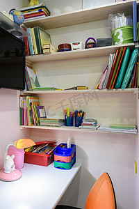 桌面整理摄影照片_儿童房的写字台，可以看到学校书架
